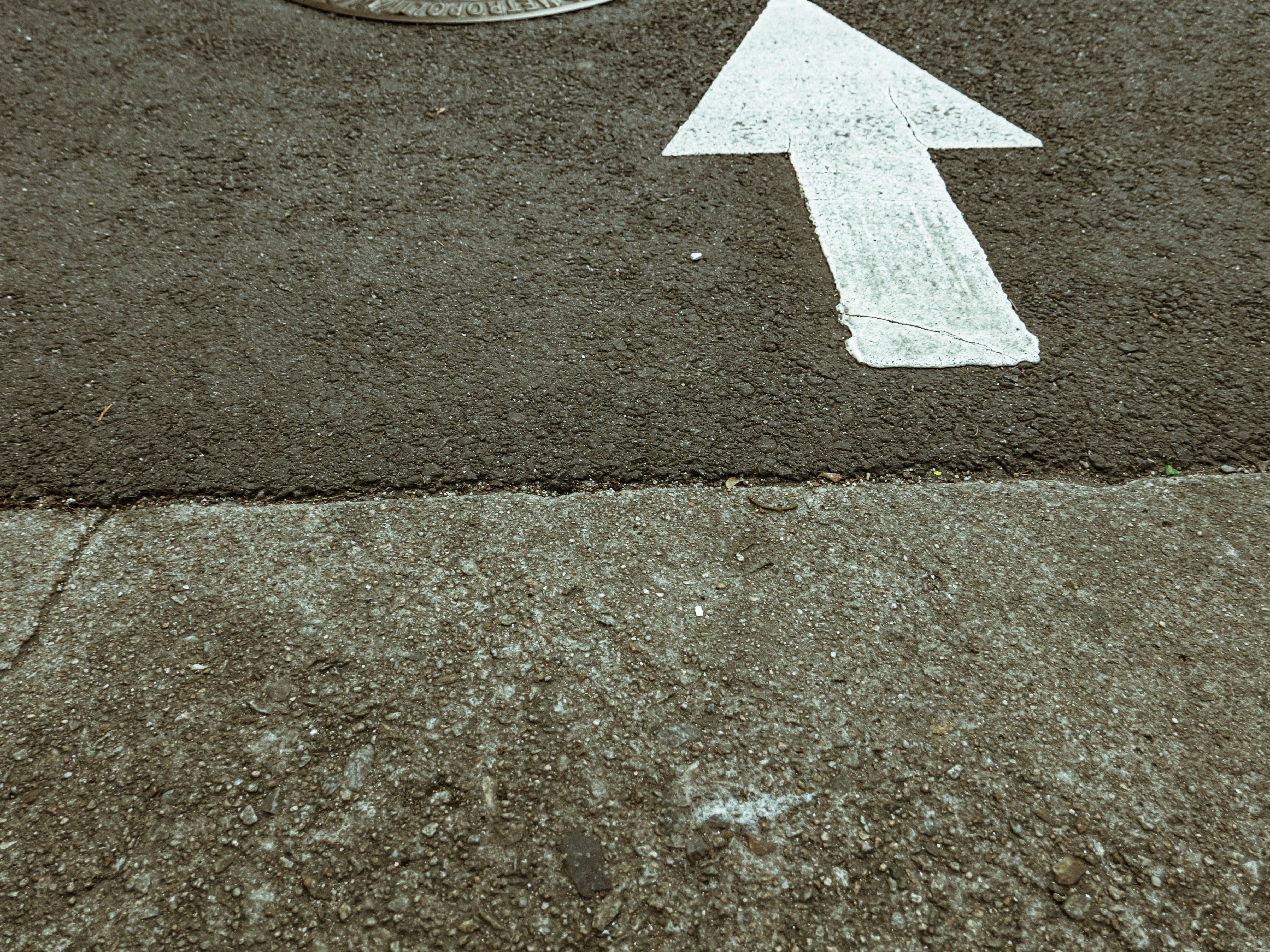 white arrow sign on gray concrete floor